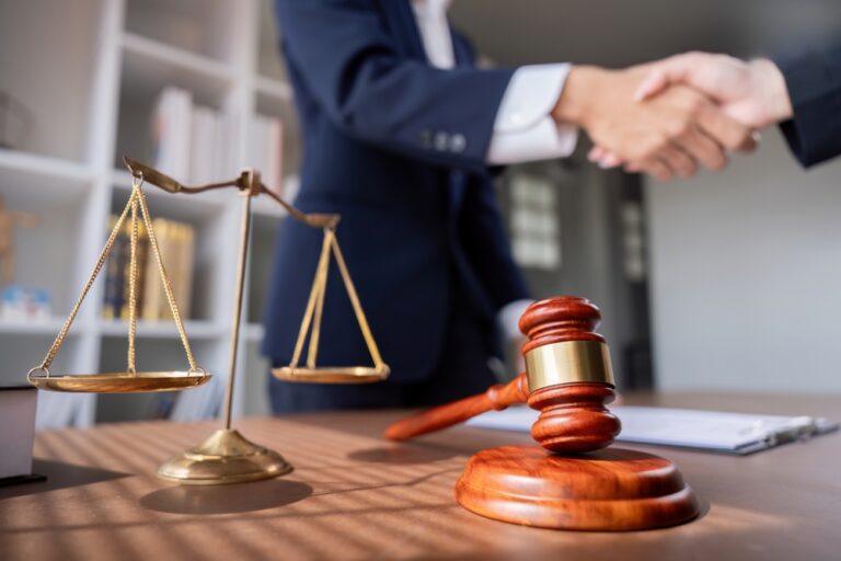 A lawyer shaking hands with a client. An attorney can explain how to file a truck accident claim against DHL.