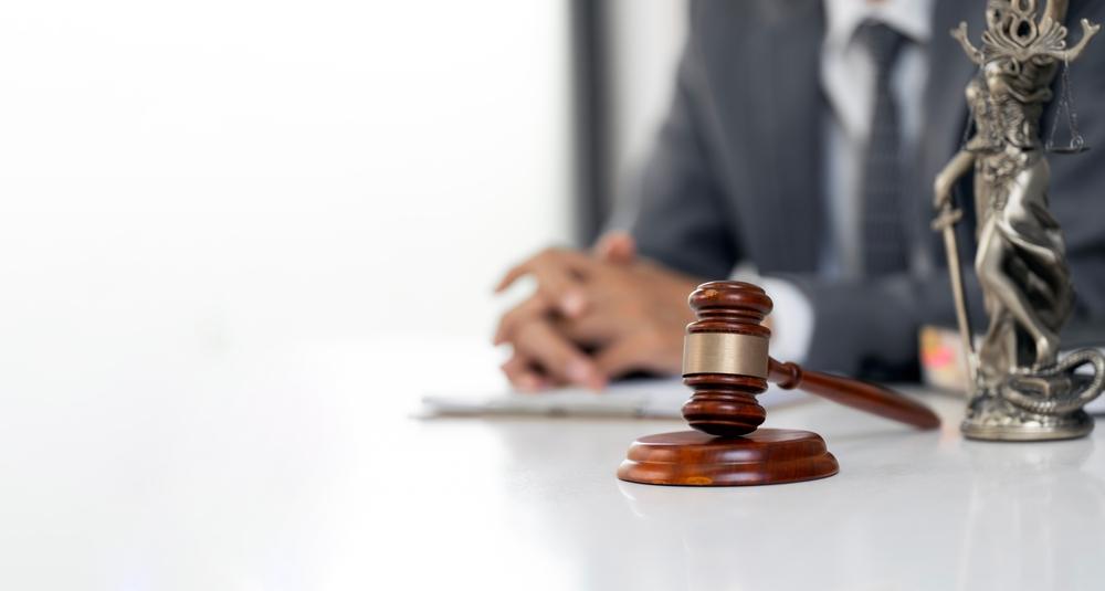 A lawyer sitting by a gavel to symbolize the question of how to file a truck accident claim against UPS.