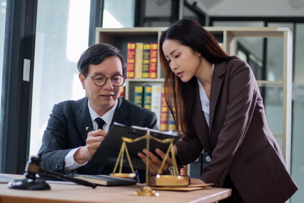 An attorney helps his client understand the answer to her question, “Do I need a lawyer after a motorcycle accident in North Carolina?”