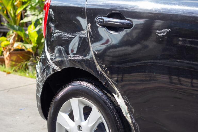 A black car damaged in a hit and run accident. Your car accident lawyer will investigate the hit and run accident.
