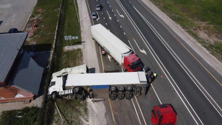 An overhead view reveals two trucks and other vehicles in the aftermath of a collision on the interstate. Onlookers wonder how to negotiate a truck accident settlement.