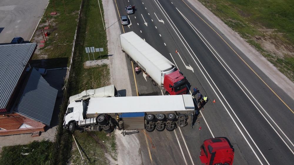 An overhead view reveals two trucks and other vehicles in the aftermath of a collision on the interstate. Onlookers wonder how to negotiate a truck accident settlement.
