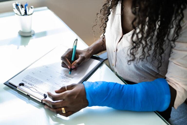 An injured rideshare passenger completes an insurance claim form. After a crash with a Lyft driver, get medical care and protect your right to recover damages with legal support.