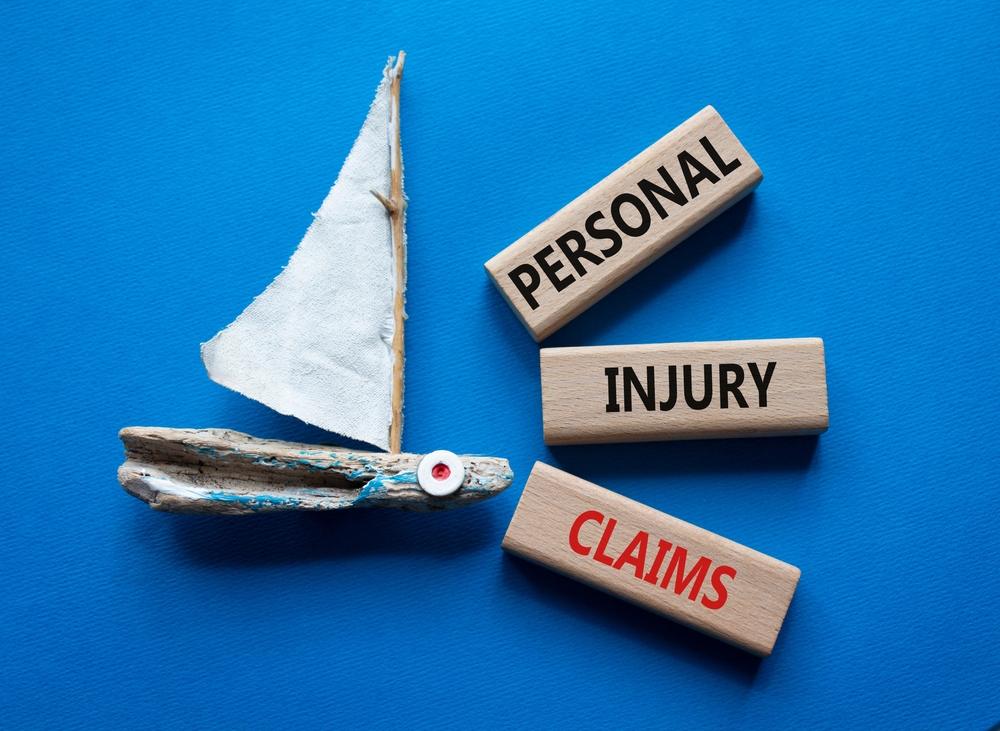 Picture of a miniature boat and blocks that say personal injury claim for an article that describes how to file a claim after a boating accident.